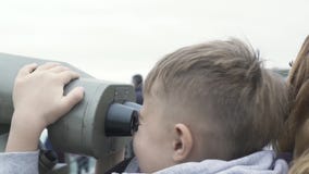 Молодой мальчик смотря панораму города туристскими биноклями на пике Гонконге Китае Виктория Туристская мальчика мать совместно акции видеоматериалы Молодой мальчик смотря панораму города туристскими биноклями на пике Гонконге Китае Виктория Туристская мальчика мать совместно акции видеоматериалы