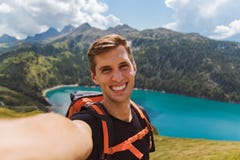Молодой счастливый человек принимает selfie на верхней части горы в швейцарских горных вершинах стоковые фото Молодой счастливый человек принимает selfie на верхней части горы в швейцарских горных вершинах стоковые фото