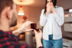 Молодой человек делает предложение к удивленной женщине стоковые изображения rf Молодой человек делает предложение к удивленной женщине стоковые изображения rf