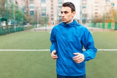 Молодой человек играет спорт, бежит на футбольном поле Парень работает в открытом, свежем воздухе стоковые изображения Молодой человек играет спорт, бежит на футбольном поле Парень работает в открытом, свежем воздухе стоковые изображения