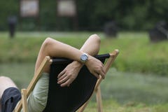 Молодой человек лежа на deckchair в саде, ослабляет, выходной день стоковые изображения rf Молодой человек лежа на deckchair в саде, ослабляет, выходной день стоковые изображения rf