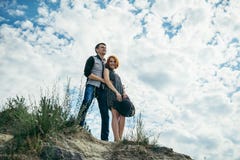 Молодой человек с женщиной стоит на холме и смотрит прямо вперед стоковые фотографии rf Молодой человек с женщиной стоит на холме и смотрит прямо вперед стоковые фотографии rf