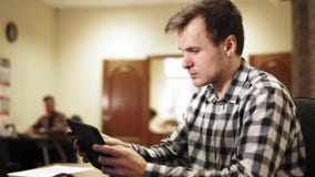 Молодой человек сидя в офисе видеоматериал Молодой человек сидя в офисе видеоматериал
