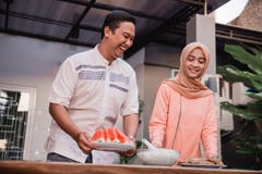 Молодые женщина и парень hijab подготавливают кухню ломая быстро к друзьям стоковое фото rf Молодые женщина и парень hijab подготавливают кухню ломая быстро к друзьям стоковое фото rf