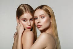 Молодые красивые стороны 2 взрослых девушек с обнаженными плечами на серой предпосылке стоковая фотография rf Молодые красивые стороны 2 взрослых девушек с обнаженными плечами на серой предпосылке стоковая фотография rf