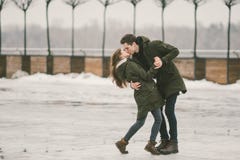 Молодые люди гетеросексуальные пары в студентах любов человек и кавказская женщина В зиме, в городской площади покрытой с льдом, стоковые изображения Молодые люди гетеросексуальные пары в студентах любов человек и кавказская женщина В зиме, в городской площади покрытой с льдом, стоковые изображения