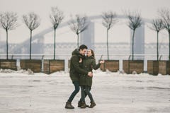 Молодые люди гетеросексуальные пары в студентах любов человек и кавказская женщина В зиме, в городской площади покрытой с льдом, стоковые фотографии rf Молодые люди гетеросексуальные пары в студентах любов человек и кавказская женщина В зиме, в городской площади покрытой с льдом, стоковые фотографии rf