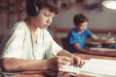 Молодые мальчики делая домашнюю работу на столе стоковое изображение rf Молодые мальчики делая домашнюю работу на столе стоковое изображение rf