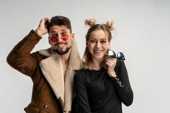 Молодые пары бородатого человека в пальто и милой женщине в черном платье с длинными светлыми волосами стоковая фотография rf Молодые пары бородатого человека в пальто и милой женщине в черном платье с длинными светлыми волосами стоковая фотография rf