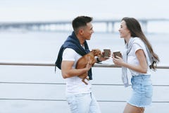 Молодые счастливые пары на прогулке с малой собакой на море гуляют стоковая фотография Молодые счастливые пары на прогулке с малой собакой на море гуляют стоковая фотография