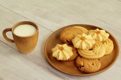 Молоко вкусного завтрака горячее в чашке глины и душистых crumbly печеньях с гайками и вареньем изюминок на керамической плите на стоковые изображения Молоко вкусного завтрака горячее в чашке глины и душистых crumbly печеньях с гайками и вареньем изюминок на керамической плите на стоковые изображения