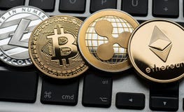Монетки Cryptocurrencies Ethereum, пульсации, Bitcoin и Litecoin на клавиатуре ноутбука компьютера стоковая фотография Монетки Cryptocurrencies Ethereum, пульсации, Bitcoin и Litecoin на клавиатуре ноутбука компьютера стоковая фотография