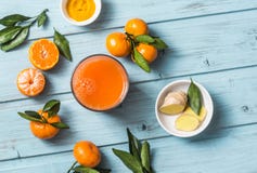Моркови, имбирь, tangerines, сок вытрезвителя турмерина свежий на голубой деревянной предпосылке, взгляд сверху vegetarian еды зд Стоковая Фотография RF Моркови, имбирь, tangerines, сок вытрезвителя турмерина свежий на голубой деревянной предпосылке, взгляд сверху vegetarian еды зд Стоковая Фотография RF