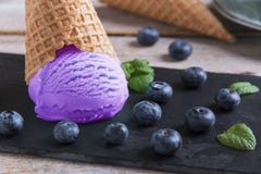 Мороженое голубики в чашке waffle на каменной поверхности стоковая фотография Мороженое голубики в чашке waffle на каменной поверхности стоковая фотография