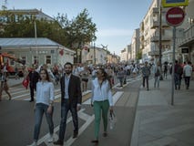 МОСКВА, РОССИЯ - 9-ОЕ МАЯ 2016: Молодой парень в костюме с 2 девушками идет вдоль улицы после полка Immortal в марше Стоковое Изображение МОСКВА, РОССИЯ - 9-ОЕ МАЯ 2016: Молодой парень в костюме с 2 девушками идет вдоль улицы после полка Immortal в марше Стоковое Изображение