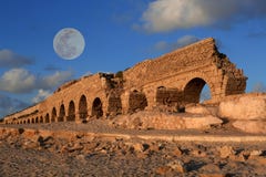 Мост-водовод в Caesarea на заходе солнца с луной стоковое фото Мост-водовод в Caesarea на заходе солнца с луной стоковое фото