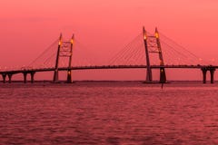 Мост дороги шоссе круга над рекой Neva около рта его в часе золота во время захода солнца стоковые фотографии rf Мост дороги шоссе круга над рекой Neva около рта его в часе золота во время захода солнца стоковые фотографии rf