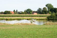 Моторка вытягивает человека на веревочке Wakeboarding на реке стоковая фотография rf Моторка вытягивает человека на веревочке Wakeboarding на реке стоковая фотография rf