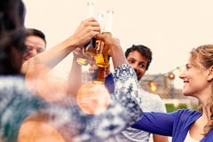 Мульти-этническая millenial группа в составе друзья partying и наслаждаясь пиво на terrasse крыши на заходе солнца стоковая фотография rf Мульти-этническая millenial группа в составе друзья partying и наслаждаясь пиво на terrasse крыши на заходе солнца стоковая фотография rf