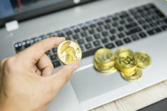 Мужская рука бизнесмена держа bitcoin титана дерева на предпосылке клавиатуры компьтер-книжки и куче золотых монеток фактически стоковая фотография Мужская рука бизнесмена держа bitcoin титана дерева на предпосылке клавиатуры компьтер-книжки и куче золотых монеток фактически стоковая фотография