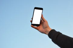 Мужская рука держа умный телефон на предпосылке неба с путем клиппирования стоковое фото Мужская рука держа умный телефон на предпосылке неба с путем клиппирования стоковое фото