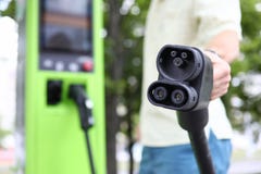 Мужская рука держа черный кабель загрузочной вагонетки автомобиля стоковые фотографии rf Мужская рука держа черный кабель загрузочной вагонетки автомобиля стоковые фотографии rf