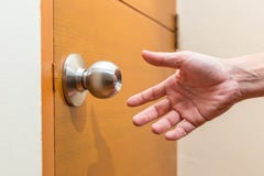 Мужская рука достигая вне для того чтобы схватить ручку двери стоковые фотографии rf Мужская рука достигая вне для того чтобы схватить ручку двери стоковые фотографии rf