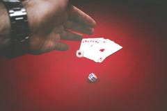 Мужской бросать руки dices на красной таблице с картами покера стоковая фотография rf Мужской бросать руки dices на красной таблице с картами покера стоковая фотография rf