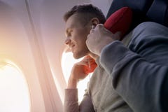 Мужской пассажир самолета слушает музыку и наслаждается подушкой для спать в стуле стоковое фото rf Мужской пассажир самолета слушает музыку и наслаждается подушкой для спать в стуле стоковое фото rf