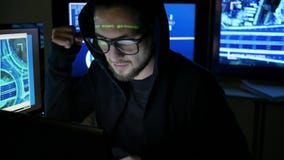 Мужской хакер работая на компьютере пока зеленые кодовые знаки отражают на стороне в темной комнате офиса, шпионаж интернета, акции видеоматериалы Мужской хакер работая на компьютере пока зеленые кодовые знаки отражают на стороне в темной комнате офиса, шпионаж интернета, акции видеоматериалы