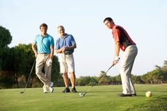 мужчина группы игроков в гольф с teeing стоковое изображение rf мужчина группы игроков в гольф с teeing стоковое изображение rf