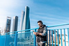 Музыка Гай красивого хипстера слушая на наушниках и мобильном телефоне использования стоковые фото Музыка Гай красивого хипстера слушая на наушниках и мобильном телефоне использования стоковые фото