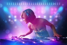 музыка диск-жокея смешивая на turntables на этапе с светами и стробоскопами Стоковая Фотография музыка диск-жокея смешивая на turntables на этапе с светами и стробоскопами Стоковая Фотография