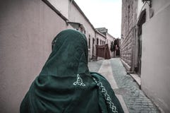 Мусульманская традиционная женщина посещая старый исторический город в Баку Азербайджане Город Innrer стоковое фото rf Мусульманская традиционная женщина посещая старый исторический город в Баку Азербайджане Город Innrer стоковое фото rf