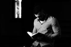 Мусульманский человек читает Koran стоковая фотография Мусульманский человек читает Koran стоковая фотография