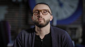 мыжские детеныши портрета Портрет молодого человека сидя в стеклах и смотря камеру на предпосылке кафа сток-видео мыжские детеныши портрета Портрет молодого человека сидя в стеклах и смотря камеру на предпосылке кафа сток-видео