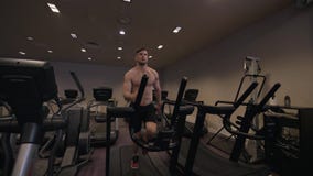 Мышечный человек делая cardio тренировку на третбане в здоровом замедленном движении клуба стоковые изображения rf Мышечный человек делая cardio тренировку на третбане в здоровом замедленном движении клуба стоковые изображения rf