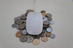 Мышь финансов интернета белая на куче монеток стоковое фото Мышь финансов интернета белая на куче монеток стоковое фото