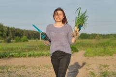 На открытом воздухе портрет весны зрелой женщины со свежими зелеными луками стоковая фотография На открытом воздухе портрет весны зрелой женщины со свежими зелеными луками стоковая фотография