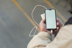 Насмешливый поднимающий вверх смартфон с портативный поручать в руках человека стоковое изображение Насмешливый поднимающий вверх смартфон с портативный поручать в руках человека стоковое изображение