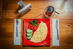 Национальное блюдо в красной стильной плите и стекле черного турецкого чая на деревянном столе стоковые изображения Национальное блюдо в красной стильной плите и стекле черного турецкого чая на деревянном столе стоковые изображения