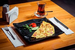 Национальное блюдо в черной стильной плите и стекле черного турецкого чая на деревянном столе стоковое фото Национальное блюдо в черной стильной плите и стекле черного турецкого чая на деревянном столе стоковое фото