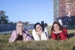 Небольшая группа в составе красивые девушки смеясь совместно лежать на траве outdoors в парке стоковое изображение rf Небольшая группа в составе красивые девушки смеясь совместно лежать на траве outdoors в парке стоковое изображение rf