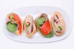 4 небольших сэндвича смешивания с pate и мясом, зажаренной паприкой на белой овальной плите стоковая фотография 4 небольших сэндвича смешивания с pate и мясом, зажаренной паприкой на белой овальной плите стоковая фотография