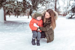 Небольшой ребенок 3-5 лет, зимы мальчика в теплой куртке и шляпы В зиме, в снеге против предпосылки зеленого цвета стоковая фотография Небольшой ребенок 3-5 лет, зимы мальчика в теплой куртке и шляпы В зиме, в снеге против предпосылки зеленого цвета стоковая фотография