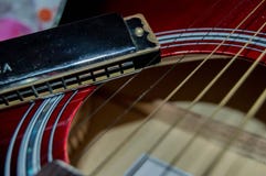 Некоторые строки гитары рядом с губной гармоникой стоковые фотографии rf Некоторые строки гитары рядом с губной гармоникой стоковые фотографии rf