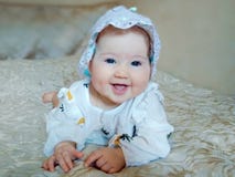 Немногое красивый младенец на бежевой кровати стоковая фотография Немногое красивый младенец на бежевой кровати стоковая фотография
