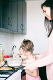Немногое сладкая девушка и ее блинчики картофеля фри матери на традиционной русской масленице Maslenitsa Shrovetide праздника стоковое фото rf Немногое сладкая девушка и ее блинчики картофеля фри матери на традиционной русской масленице Maslenitsa Shrovetide праздника стоковое фото rf