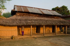 Непальская женщина, Chitwan, Непал и дом стоковая фотография rf Непальская женщина, Chitwan, Непал и дом стоковая фотография rf