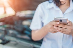 Непознаваемая молодая женщина со сломленным автомобилем спуска вызывая мобильным телефоном стоковые изображения rf Непознаваемая молодая женщина со сломленным автомобилем спуска вызывая мобильным телефоном стоковые изображения rf
